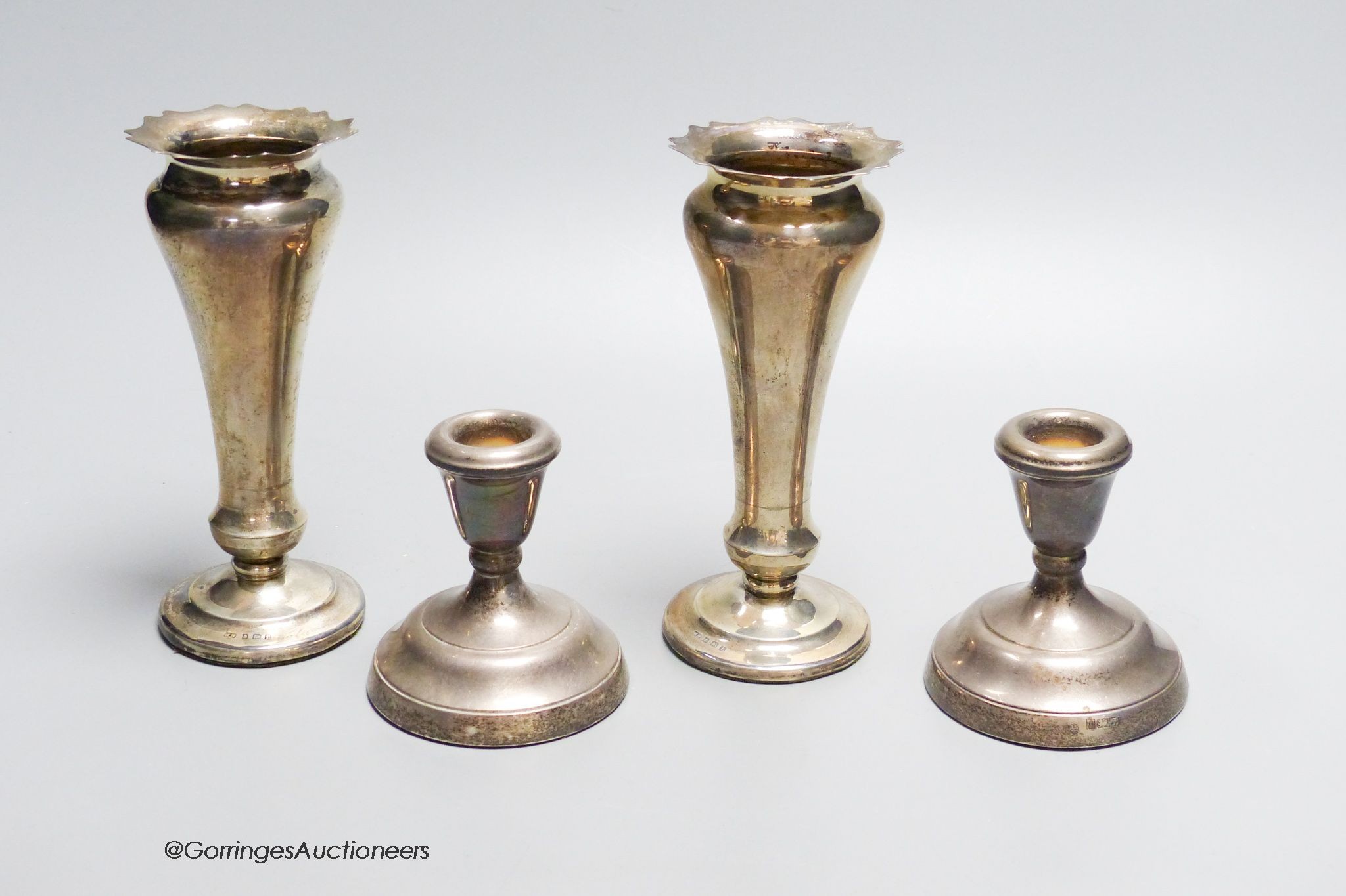 A pair of loaded silver vases, Birmingham 1935, 15 cm high and a similar pair of silver dwarf candlesticks, Birmingham 1980, 8 cm high